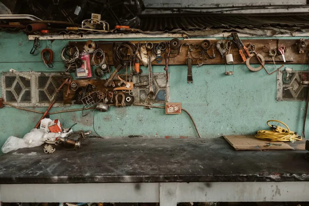 A wall of old tools above a workbench
